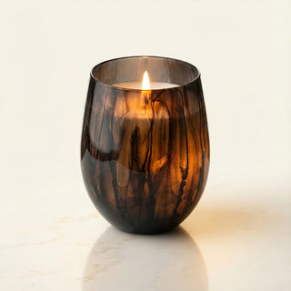 Earth’s Embrace Feng Shui earth element luxury candle lit with warm flame in hand-painted black marbled glass vessel