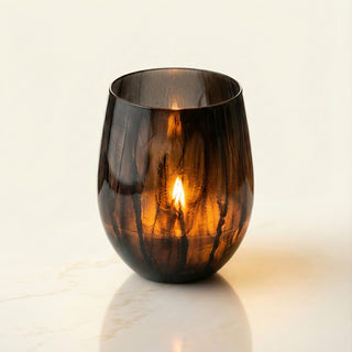 Earth’s Embrace Feng Shui earth element luxury candle burning with deep amber flame in hand-painted black marbled glass vessel