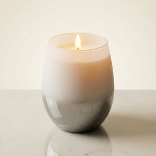 Elegant Whisper Feng Shui metal element luxury candle lit with soft golden flame in white-to-smoke ombré glass vessel
