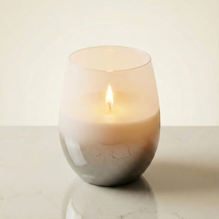 Elegant Whisper Feng Shui metal element luxury candle burning with deep golden melt pool in white-to-smoke ombré glass