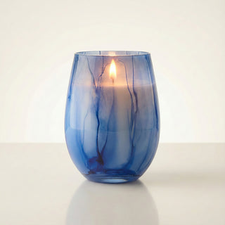 Azure Coastal Bliss Feng Shui water element luxury candle lit with glowing flame in hand-painted blue marbled glass vessel