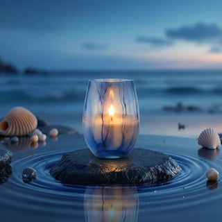 Azure Coastal Bliss Feng Shui water element luxury candle lit at twilight on beach with seashells and ocean reflection
