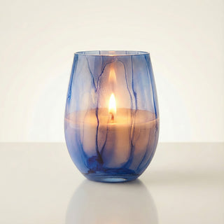 Azure Coastal Bliss Feng Shui water element luxury candle burning with warm golden flame in hand-painted blue marbled glass vessel