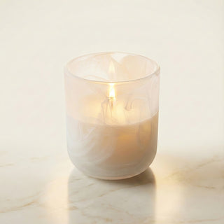 Yang – Light Shadow premium coconut apricot wax candle lit with soft warm glow, sophisticated white marbled artisan glass vessel casting luminous diffused light