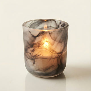 Yin – Shadow Light premium coconut apricot wax candle burning softly, elegant black and gray marbled frosted glass vessel casting ethereal glow