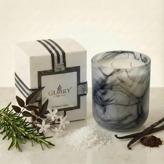 Glory Strength Shadow Light 2-wick luxury candle with gift box and fragrance notes displayed: rosemary, black jasmine flowers, sea salt, vanilla pods, on a white marble surface
